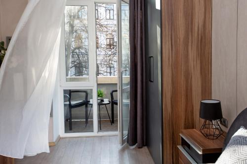 a bedroom with a sliding glass door with a table at Apartment & Parking "Opera at the corner" in Odesa