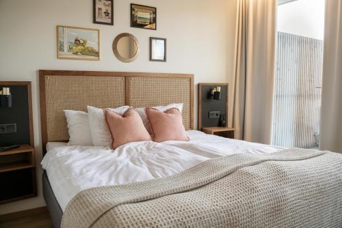 a bedroom with a large white bed with pink pillows at Fritiden Hotell & Kongress in Ystad