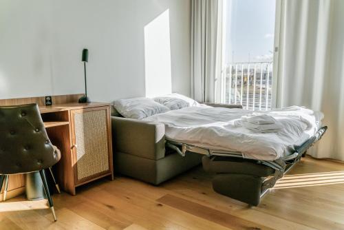 a bed sitting in a room next to a window at Fritiden Hotell & Kongress in Ystad