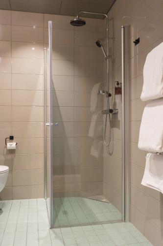 a shower with a glass door in a bathroom at Fritiden Hotell & Kongress in Ystad