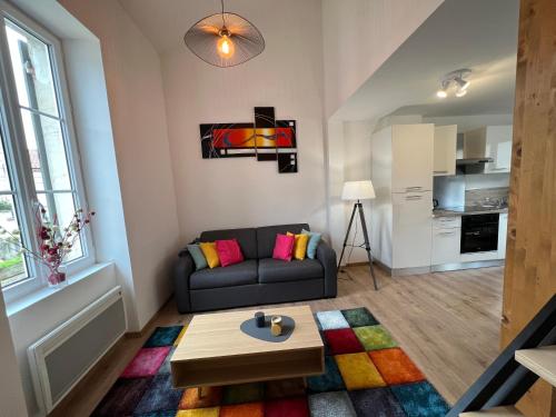 uma sala de estar com um sofá e uma mesa em Appartement 6 - hyper-centre Agen avec Garage em Agen