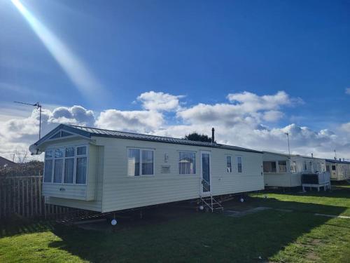 a white mobile home parked in a yard at Slatersaunders56 in Meliden