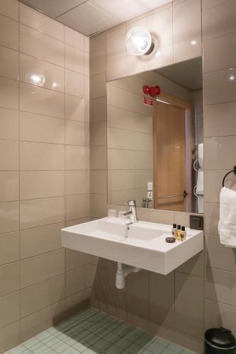 a bathroom with a sink and a mirror at Fritiden Hotell & Kongress in Ystad