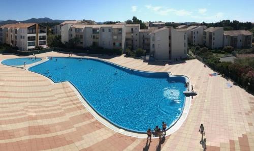 une piscine devant certains immeubles d'habitation dans l'établissement Le Philippine - Résidence Piscine - Garage privé - Tennis, à Fréjus