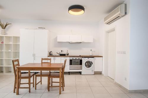 a kitchen with a table and chairs and a stove at Modern studio apartment in the heart of St Julians in St. Julianʼs
