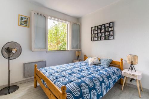 um quarto com uma cama, uma janela e uma ventoinha em Le Philippine - Résidence Piscine - Garage privé - Tennis em Fréjus