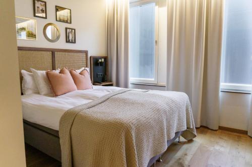 a bedroom with a large bed with pink pillows at Fritiden Hotell & Kongress in Ystad