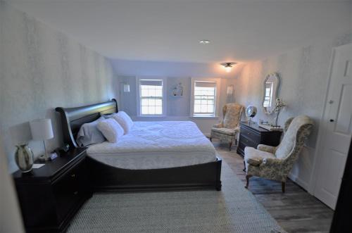 um quarto com uma cama, uma secretária e cadeiras em Blue Bear inn em Francestown