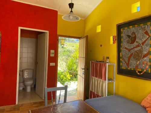une salle de bains avec des toilettes et un mur rouge et jaune dans l'établissement Posada Niña Margarita, à Priego de Córdoba
