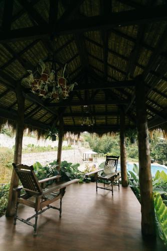 a patio with two chairs and a roof at La Joya Farm Resort & Spa in Aloguinsan