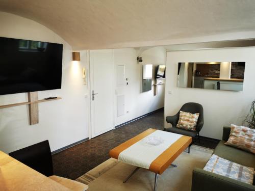 uma sala de estar com um sofá, uma mesa e uma televisão em Boardinghouse Wiebke - Ferienwohnung Oldenburg em Oldenburg