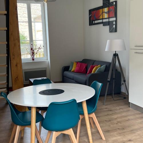 uma sala de estar com uma mesa e cadeiras e um sofá em Appartement 6 - hyper-centre Agen avec Garage em Agen