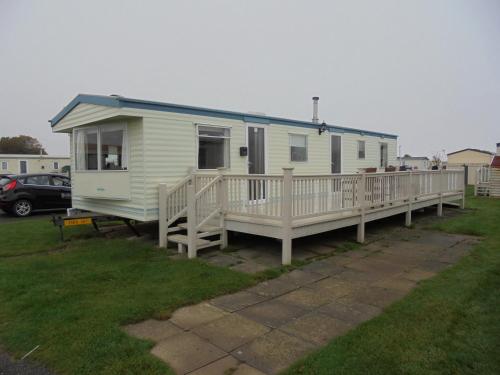a mobile home with a porch and a deck at 6 Berth 3 bedroom panel heated on Kingfisher Florida in Ingoldmells