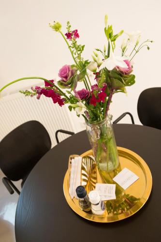 a vase filled with flowers sitting on a table at Hotel Zilt Studio's in Vlissingen