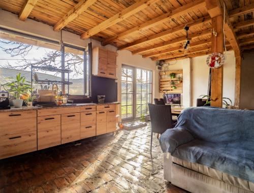 a kitchen with wooden cabinets and a couch in a room at Вила "Намасте" с панорамна гледка и камина на дърва in Lovech