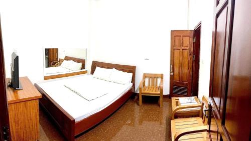a bedroom with a bed and a dresser and a mirror at Nam Khánh Motel in Hanoi