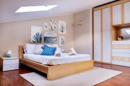 um quarto com uma cama com lençóis brancos e almofadas azuis em Daniele's Suite. Etna, Sea & much more... em Fleri