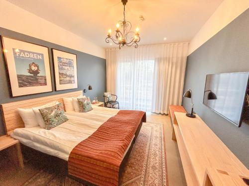 a bedroom with a large bed and a chandelier at Tofta Herrgård in Lycke