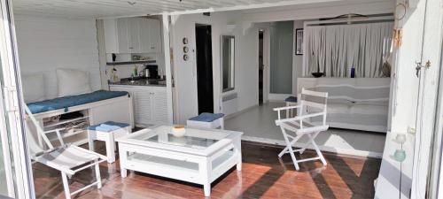 uma sala de estar com mobiliário branco e uma cozinha em Villa Village Naturiste Nirvana em Cap d'Agde