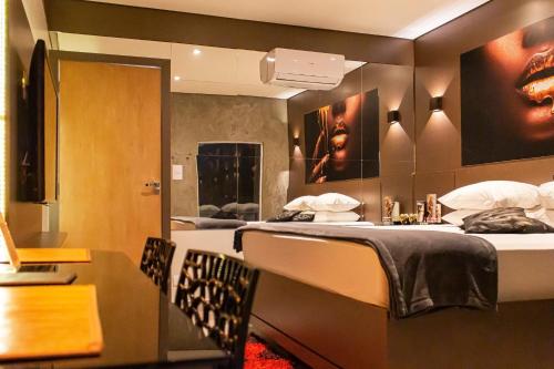 a hotel room with two beds and a table and chairs at Uno Prime Motel - Av Aricanduva in São Paulo