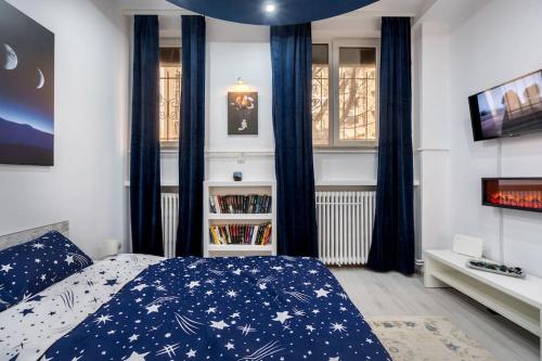a bedroom with a bed with a blue comforter at Galaxy studio near Bucharest Old Town in Bucharest