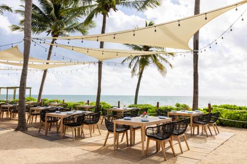 a restaurant on the beach with tables and chairs at Hyatt Zilara Riviera Maya Adults Only All-Inclusive in Playa del Carmen