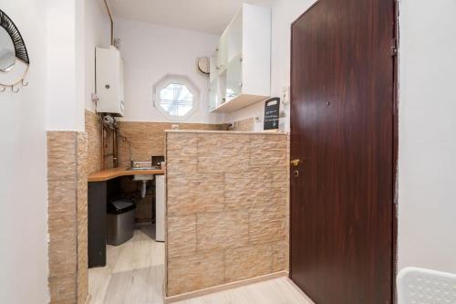 a kitchen with a wooden door in a room at Galaxy studio near Bucharest Old Town in Bucharest