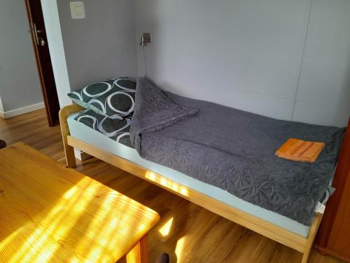 a small bed in a room with a wooden floor at Willa Dniestrzanka in Krynica Zdrój