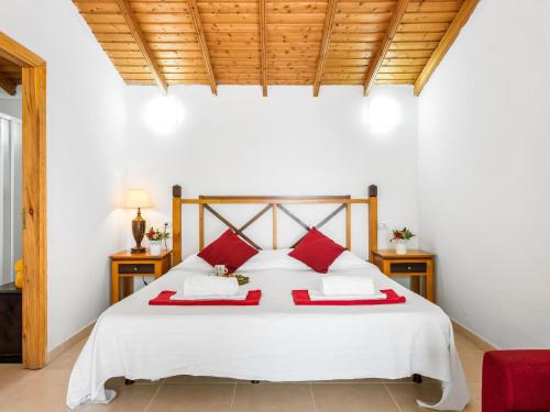 1 dormitorio con cama blanca y almohadas rojas en 102 Bright Accomodation with Pool View, en Adeje