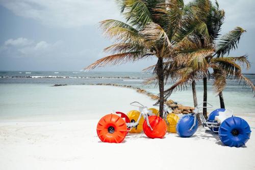a group of motorcycles parked on a beach with palm trees at AmazINN Places Playa Escondida in María Chiquita
