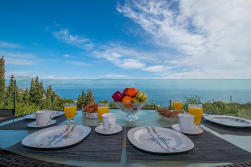 una mesa con platos de comida y un bol de fruta en DN Beach Coast Villa, en Skinária