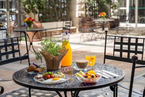 una mesa con una bandeja de fruta y bebidas. en Prima Palace Hotel, en Jerusalén