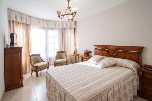 a bedroom with a bed and two chairs and a window at Club Villamar - La Gamba in Sant Feliu de Guixols