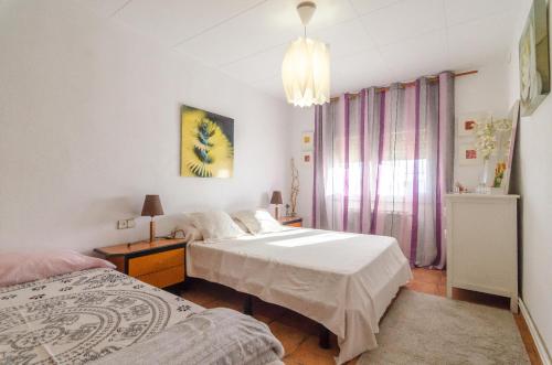 1 dormitorio con 2 camas y lámpara de araña en Club Villamar - Llanega, en Maçanet de la Selva