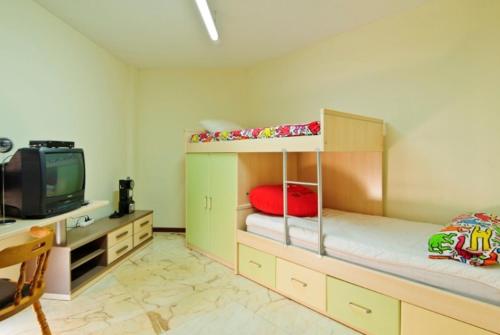 1 dormitorio con 2 literas y TV en Club Villamar - Apartment Las Vegas, en Sant Antoni de Calonge
