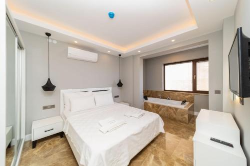 a bedroom with a bed and a tub and a television at Fully Furnished Flat with Sea View in Kas Antalya in Kas