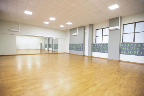 a large empty room with a wooden floor and windows at Interferie Sport Hotel Bornit in Szklarska Poręba