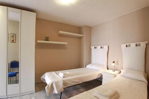 Zimmer mit 2 Betten und einem Spiegel in der Unterkunft Club Villamar - Apartment Amatella in Sant Antoni de Calonge