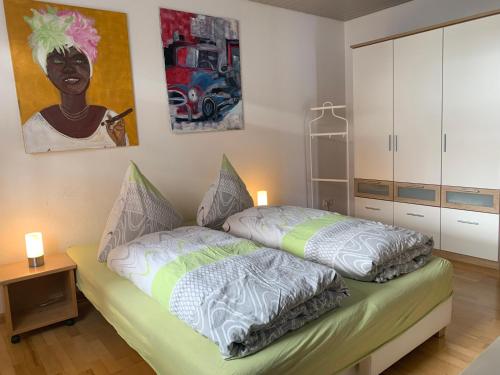1 dormitorio con 1 cama y una pintura en la pared en Ferienwohnung Haffner, en Kandern