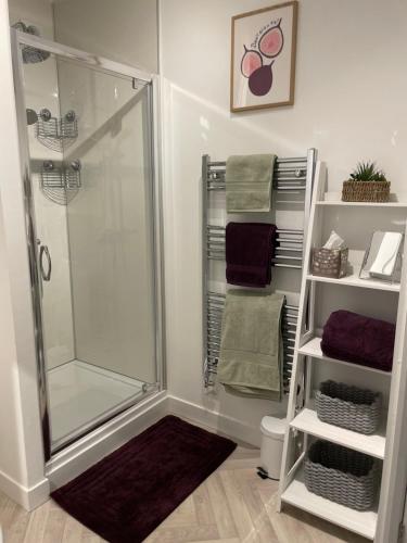 y baño con ducha, aseo y toallas. en Victoria Apartment 2, en Torquay