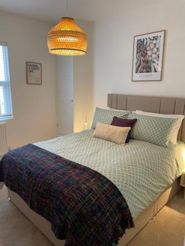 a bedroom with a bed with a checkered blanket at Victoria Apartment 2 in Torquay