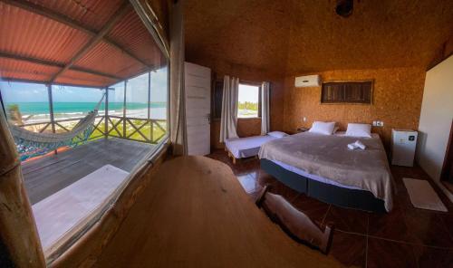 a bedroom with a bed and a view of the ocean at Casa Janjão in Icaraí