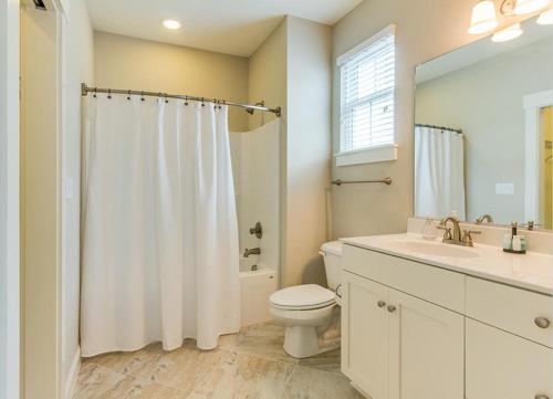 a white bathroom with a toilet and a sink at 406B The North End House in Virginia Beach