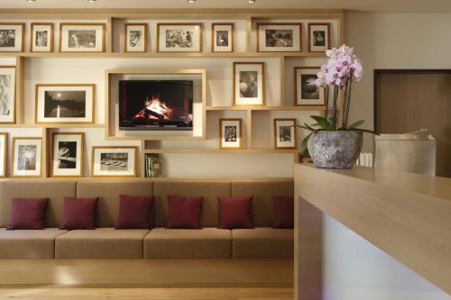 a living room with a couch and a fireplace at Logis Hôtel Kur- und Wellnesshaus Spree Balance in Burg