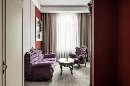 a room with purple chairs and a table and a window at Grand Hotel Lviv Casino & Spa in Lviv