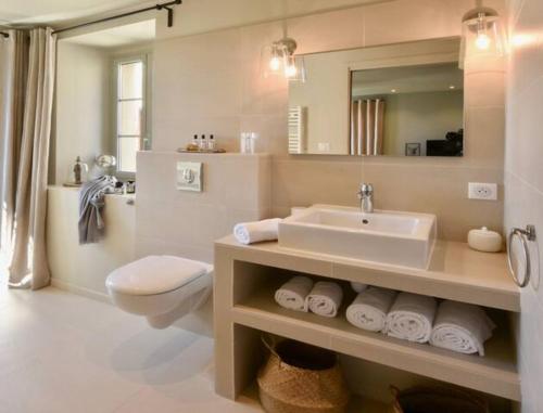 y baño con lavabo, aseo y espejo. en Maison Madamicella en Fozzano