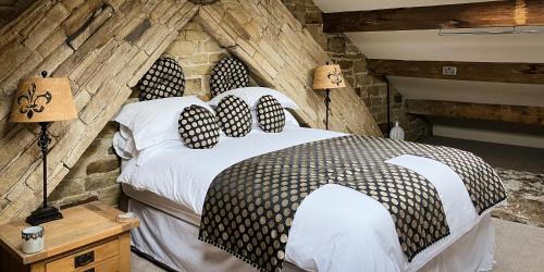 een slaapkamer met een groot bed met 2 lampen bij The Weavers Shed in Huddersfield