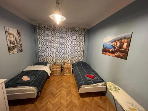 una camera da letto con due letti e un dipinto sul muro di Your Space in Sofia a Sofia