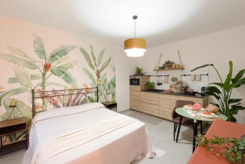 um quarto com uma cama e uma cozinha com plantas em BOTANIC GUESTHOUSE ESTE em Este