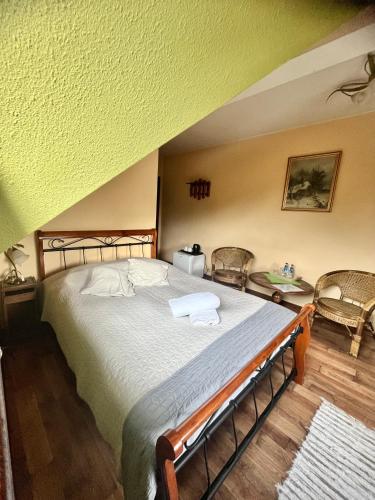 a bedroom with a large bed and two chairs at Zajazd Cicha Woda in Maniowy